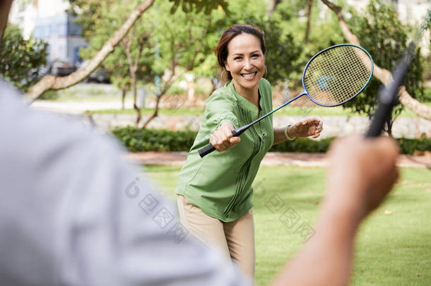 相当成熟的亚洲女人在夏天打羽毛球