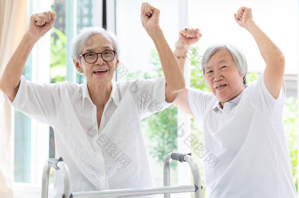 幸福的两位亚洲老妇人举起拳头和欢呼，时光相伴，老妇或姐姐的朋友微笑，欢笑和举手，老人的友谊，<strong>退休</strong>年龄