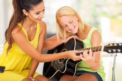 优美的音乐老师辅导年轻女孩弹吉他