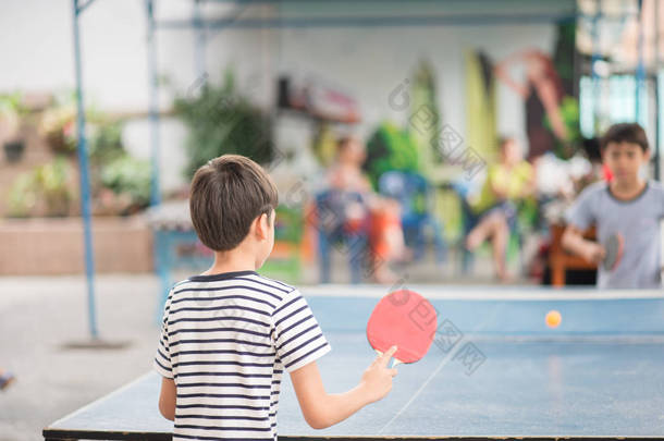 儿童与<strong>家人</strong>在户外打乒乓球
