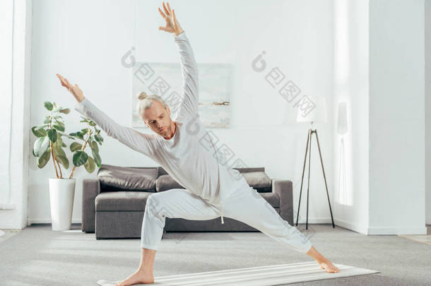 运动成人男子在垫子上练习瑜伽在家里