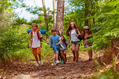 一群孩子在学校夏天的旅行中牵着手微笑着奔跑着森林小径