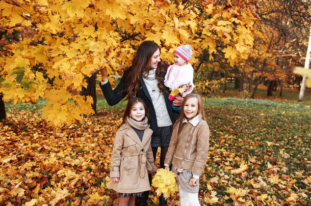快乐的家庭在秋天<strong>散步</strong>。母亲和三女儿在<strong>公园散步</strong>, 享受美丽的秋天自然.