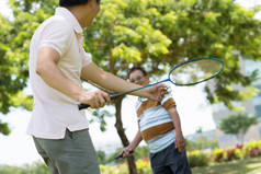 成人男子打羽毛球与他的父亲