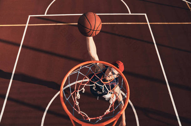 运动服装中的年轻人的最高视野在户外打篮球时得分扣篮       