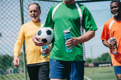 多文化老年男子与运动水壶和足球球的部分观点
