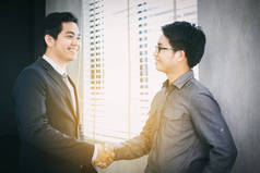 亚洲商务人士握手和微笑他们的协议 