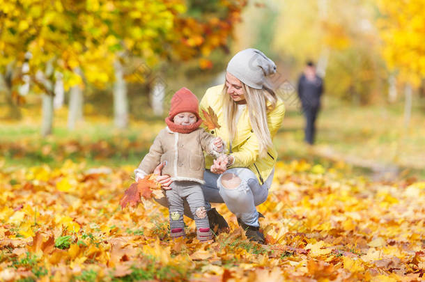 妈妈和小女儿在秋天散步。水平肖像
