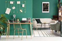 一个自由作家的家庭办公室用打字机由绿色墙壁与金黄框架组织者在时髦客厅内部