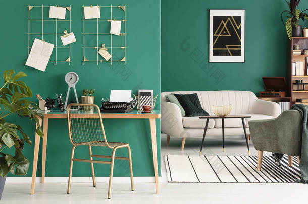 一个<strong>自由</strong>作家的家庭办公室用打字机由绿色墙壁与金黄框架组织者在时髦客厅内部