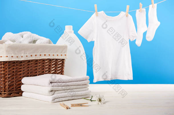 洗衣篮, 塑料容器与洗衣液, 一堆干净柔软的毛巾和白色衣服挂在晾衣绳上的蓝色  