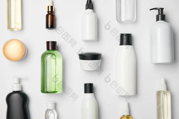 白色背景上不同的<strong>化妆品瓶</strong>和容器的顶视图