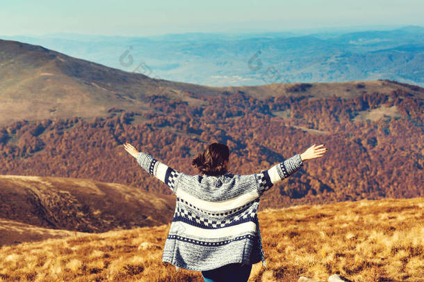 快乐的女人在山顶张开双手。自由和健康的生活方式。美丽的秋天风景. 