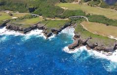 塞班岛东海岸是一个展示郁郁葱葱的风景, 高尔夫球场与陡峭的悬崖线与海浪滚滚从太平洋.