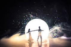 晚上在月光下跳舞的玩具夫妇的身影。数字的男人和女人在爱在月光下跳舞