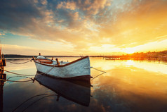 平静的湖面和反映我的天空一只小船美丽的日落
