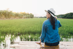 年轻的亚洲女人笑在帽子。女孩享受美丽的自然与日落。旅游暑假假期与休闲理念.