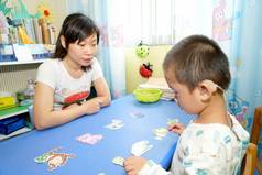 2017年5月27日，在中国南部的广西壮族自治区五州市，一名残疾男孩在老师的帮助下学习说话和倾听。