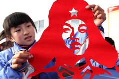 2013年3月4日，在中国东部的山东省赵庄市，一名学生展示了她的雷锋（或雷锋）头像的剪纸作品