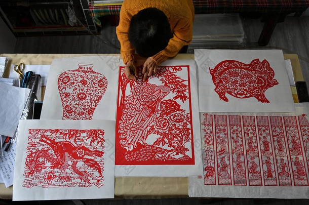 2019年1月10日，在<strong>中国</strong>东部山东省烟台市的一个车间里，一位女工匠在做剪纸艺术品
