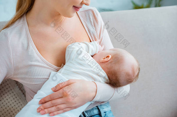 年轻女子母乳喂养幼女在家里的剪切镜头