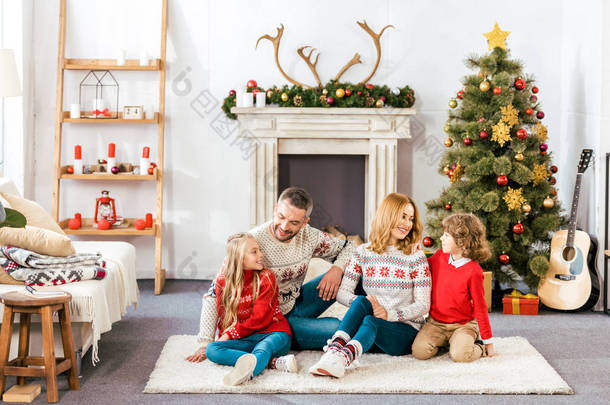 父母和孩子们一起坐在地板上圣诞节在家