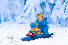 在雪橇上玩耍的孩子骑在冬天