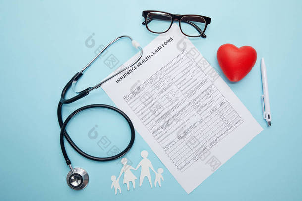 保险健康报销单、眼镜、剪纸系列、红色心脏符号和蓝色听诊器的顶级视图 
