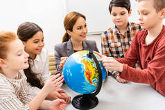 教师和学生在课堂上学习地理时看地球