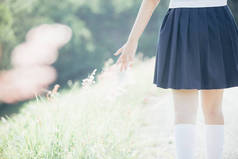 亚洲日本学校女孩服装与小花漫步在公园户外电影复古风格的肖像