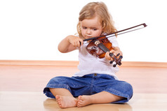 在用一把小提琴在地板上的小女孩