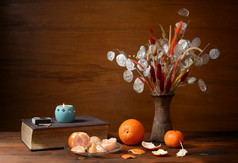 新鲜的橘子和干花插在花瓶里
