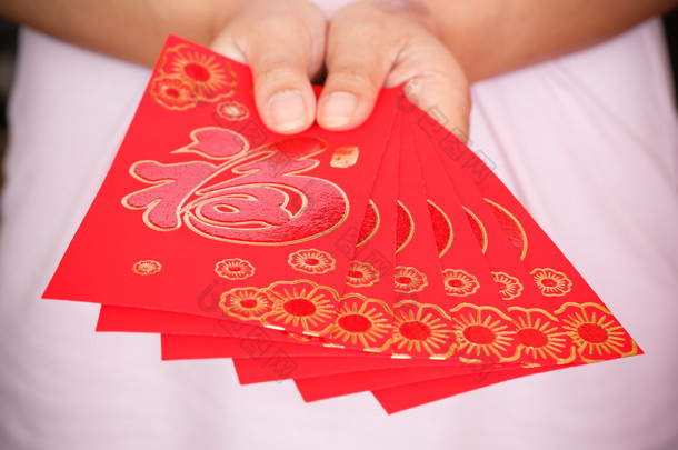 春节快乐，女人手拿着红色信封的礼物 
