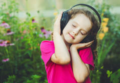 女孩闭上眼睛，听听音乐头戴式耳机。Instagra