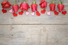 用心木制背景上的红色和粉色的玫瑰。情人节 
