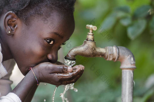 美丽的非洲孩子喝从<strong>水龙</strong>头 （水稀缺符号）。年轻的非洲女孩从<strong>水龙</strong>头喝干净的水。从<strong>水龙</strong>头在非洲城市马里巴马科街头倒水.