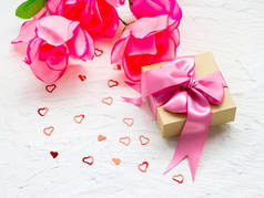 照片粉红色礼品盒与丝绸丝带, 美丽的紫色野花花束, 蜡烛和白色的空白贺卡在家里的桌子上, 节日模糊背景, 母亲节, 爱的概念