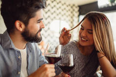 在庆祝情人节或周年纪念日时喝红酒的一对美丽浪漫情侣特写.