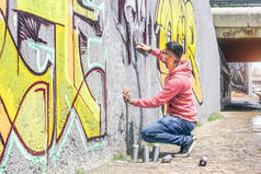 街头涂鸦艺术家画的彩色喷雾可以一个黑暗的怪物头骨涂鸦墙上的城市户外-城市, 生活方式当代街头艺术概念-主要集中在他的手