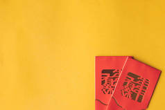 黄色背景上红色包的顶部视图 (李安)。农历新年的概念。文本的可用空间