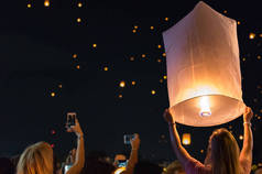 在泰国清迈灯节节或漂浮灯笼节释放漂浮灯笼的妇女.