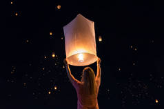 在泰国清迈的 loy krathong 节日或浮动灯笼节中释放漂浮灯笼的妇女.