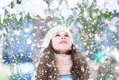 冬天森林里的小女孩用雪抬头望着冷杉的树枝。等待奇迹, 许下圣诞祝福.
