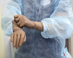 一名女外科医生准备手术手术, 戴上无菌的手术手套, 揉他的手。