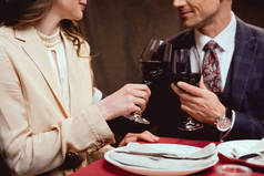在餐厅浪漫约会时, 红葡萄酒的情侣酒杯的部分视图