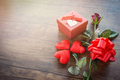 情人节礼品盒红色在木头背景/浪漫的红色心脏情人节红色玫瑰花和礼物箱子丝带弓在老木头-爱概念顶视图拷贝空间
