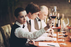 一群侍酒师在餐厅制作葡萄酒卡。品尝精英酒精饮料.