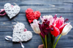 红木心在黑暗的桌子上的盒子里，周围有粉色、紫色的花瓣。 情人节，母亲节，浪漫的概念 