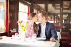 浪漫情侣亲吻坐在优雅的餐厅