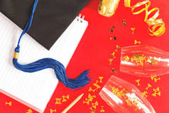 黑色毕业帽，红色带蓝色丝带